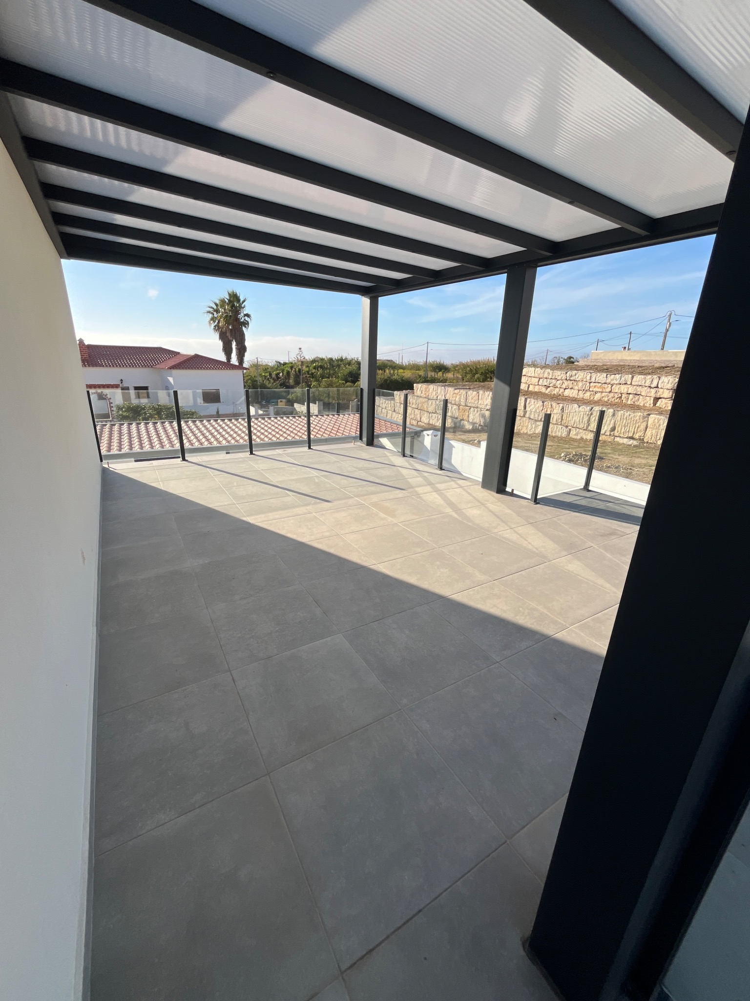 Terraço coberto com guarda em vidro