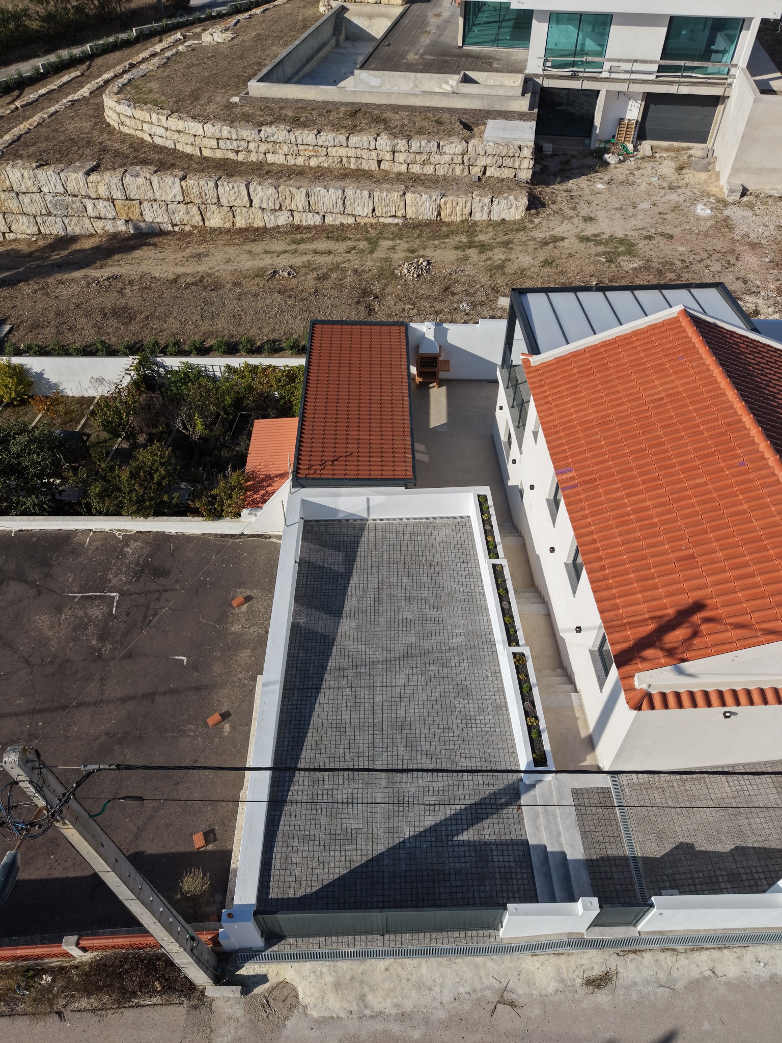 Vista aérea da entrada e da zona pavimentada junto à moradia